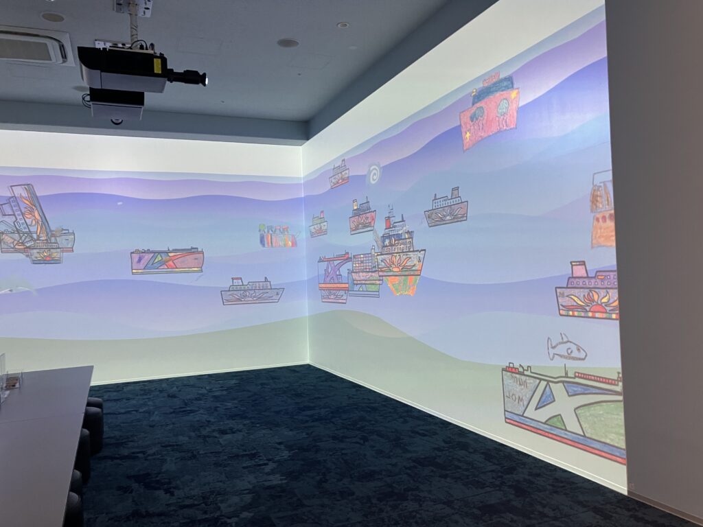 来館者が描いた船の絵が壁面を動くふねしるの映像展示