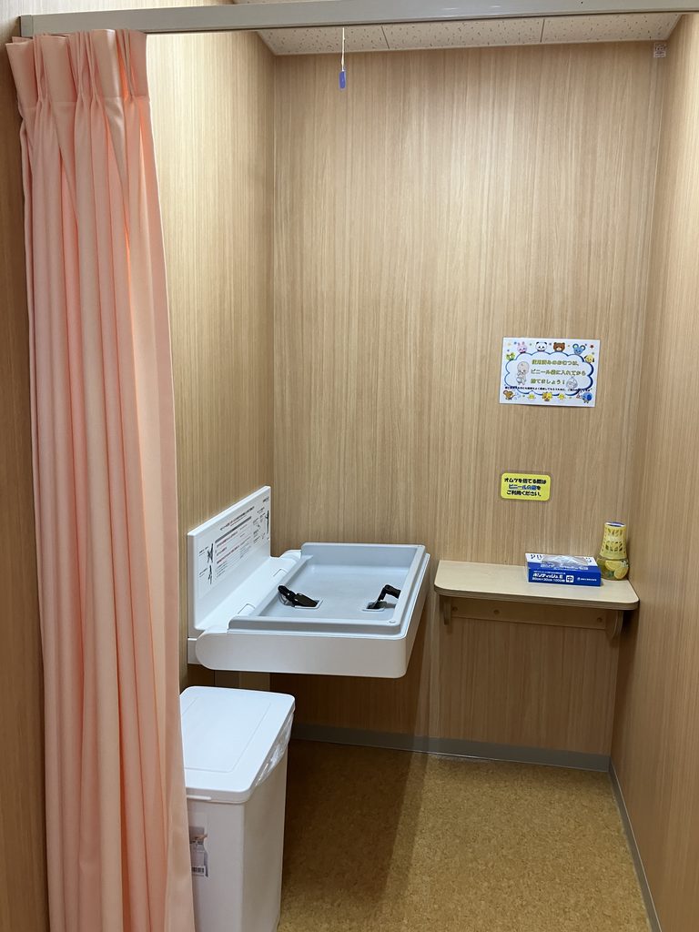 カーテンで仕切られたおむつ替え台
