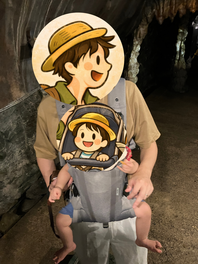抱っこ紐に抱かれる子どもと、坑道内の薄暗い通路