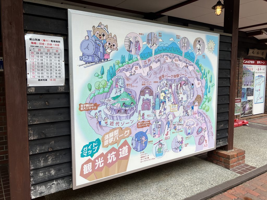 観光坑道のガイドマップ。江戸ゾーン・近代ゾーン・遊学パーク体験ゾーンの位置関係と、鉱山列車の発車時刻表が確認できる