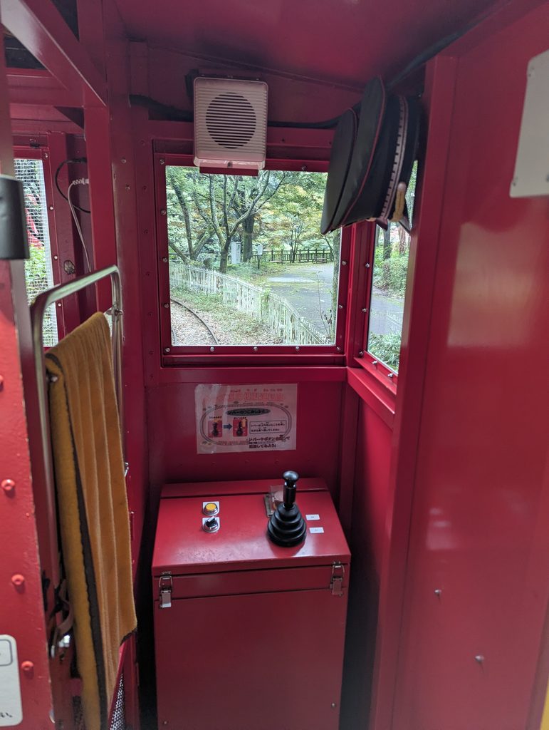 キッズ専用車内の疑似運転体験スペース。運転レバーやボタン、車掌帽が並ぶ