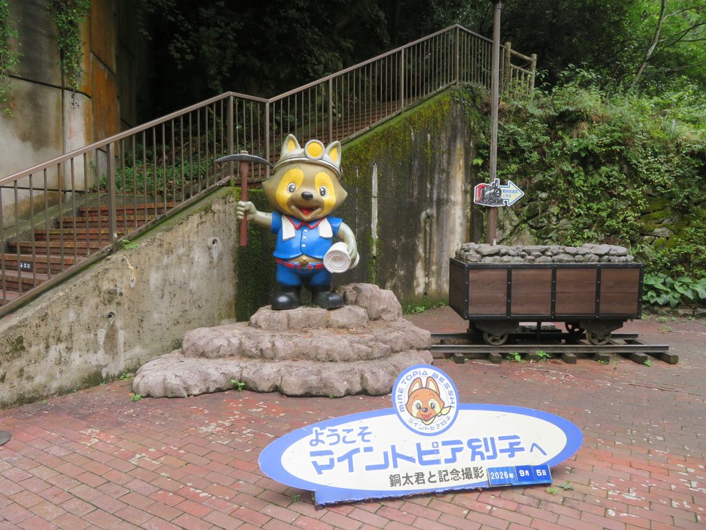 「ようこそマイントピア別子へ」の看板とマスコット銅太くんの像、記念撮影スポット